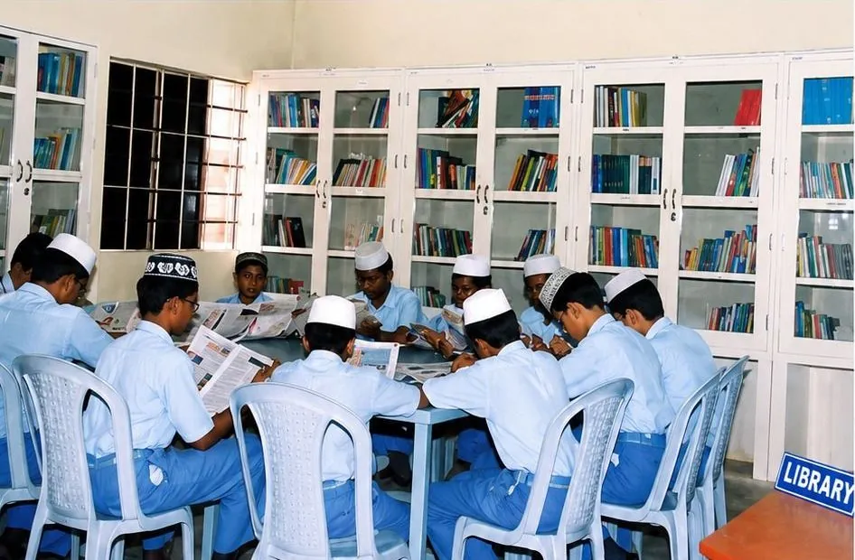 Students reading newspapers and reference books in the school library